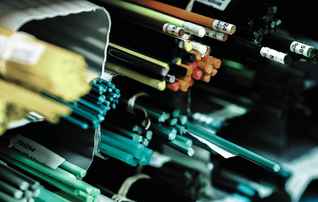 Fiber optic cables with labeled connectors showing color-coded wires in telecommunications equipment